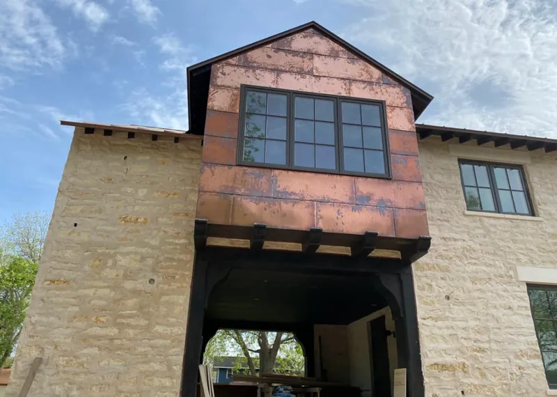 Copper metal panel facade on a stone building for Skylight Installation in Harvest