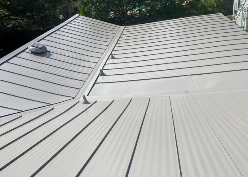 Solar attic fan installed on a metal roof for Roof Ventilation in Harvest